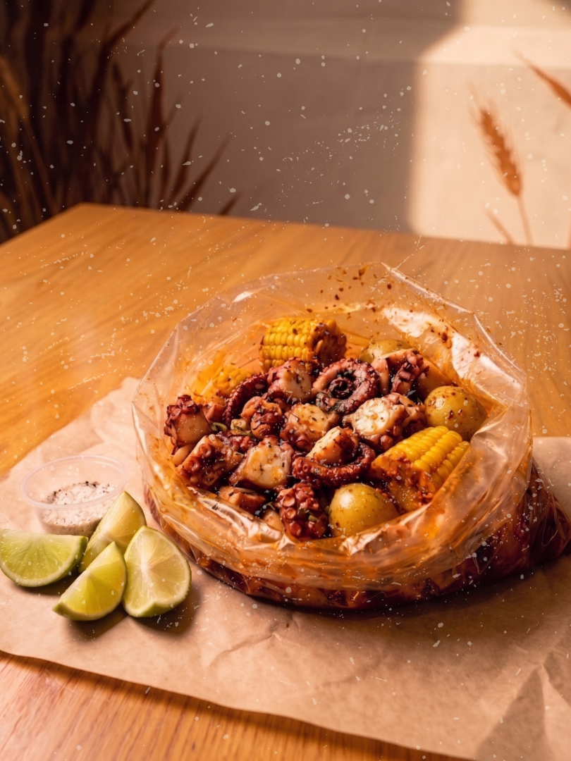 Pulpo cajún en bolsa con papa cambray, elote y limones